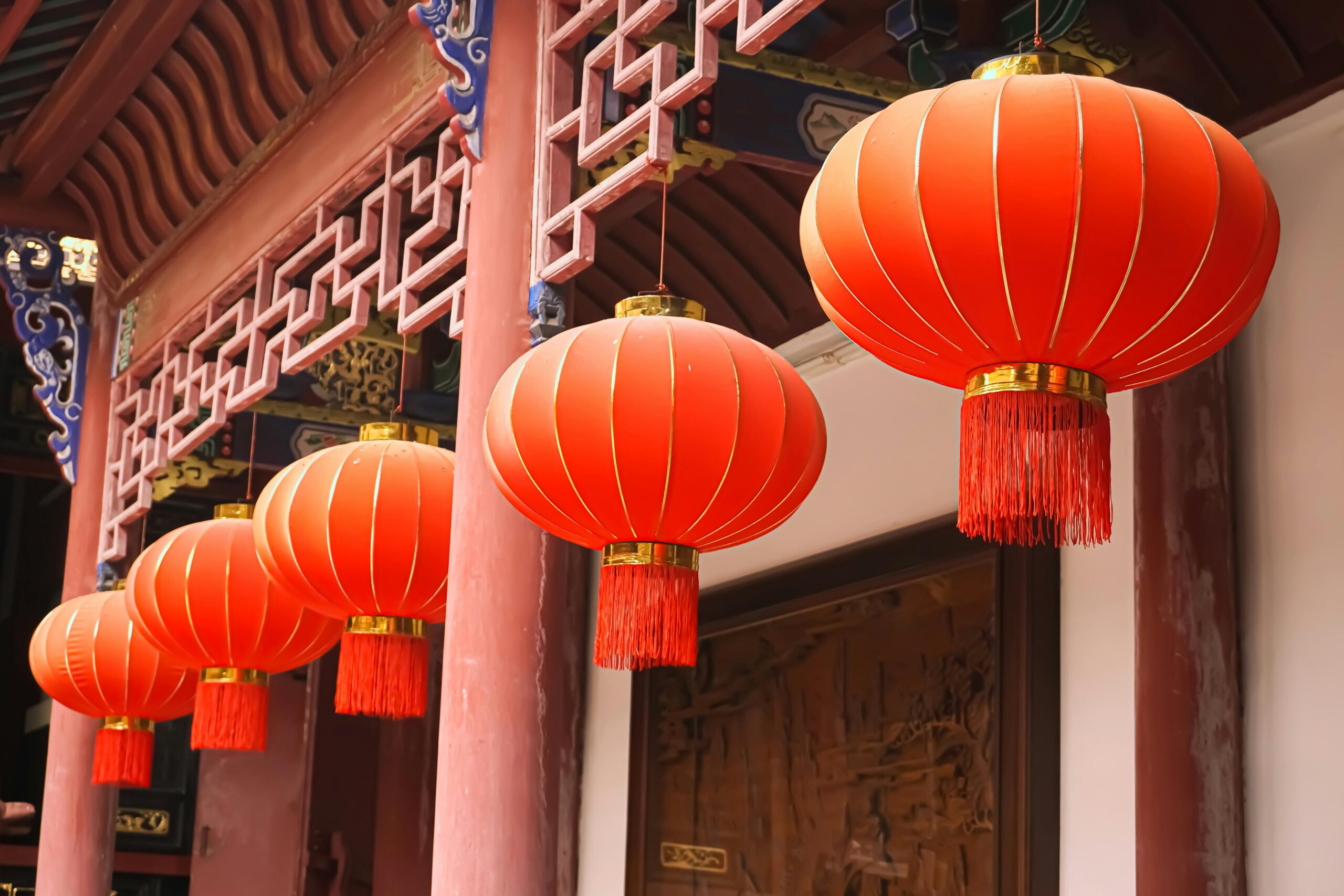 Traditional red Chinese lanterns hanging in a row, showcasing cultural decor.